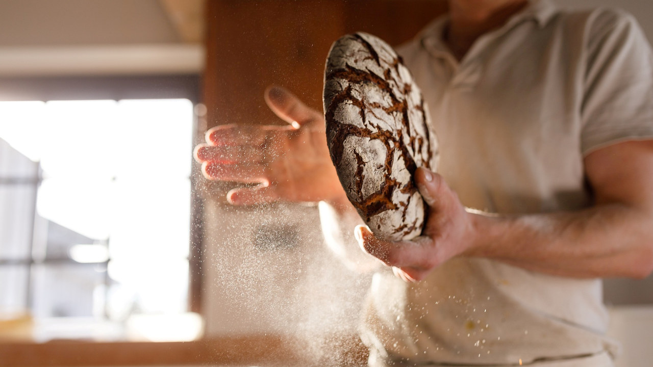 bilde av en baker som holder et brød